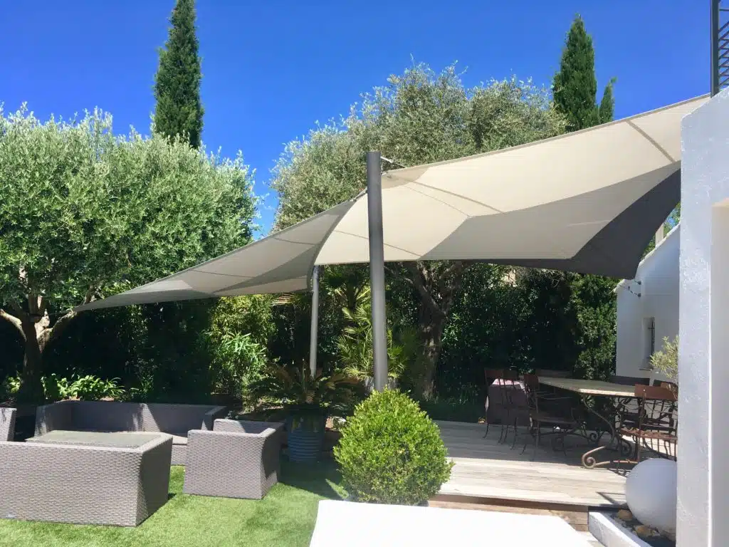 voiles d'ombrage fixées à d'élégants poteaux pour abriter la terrasse