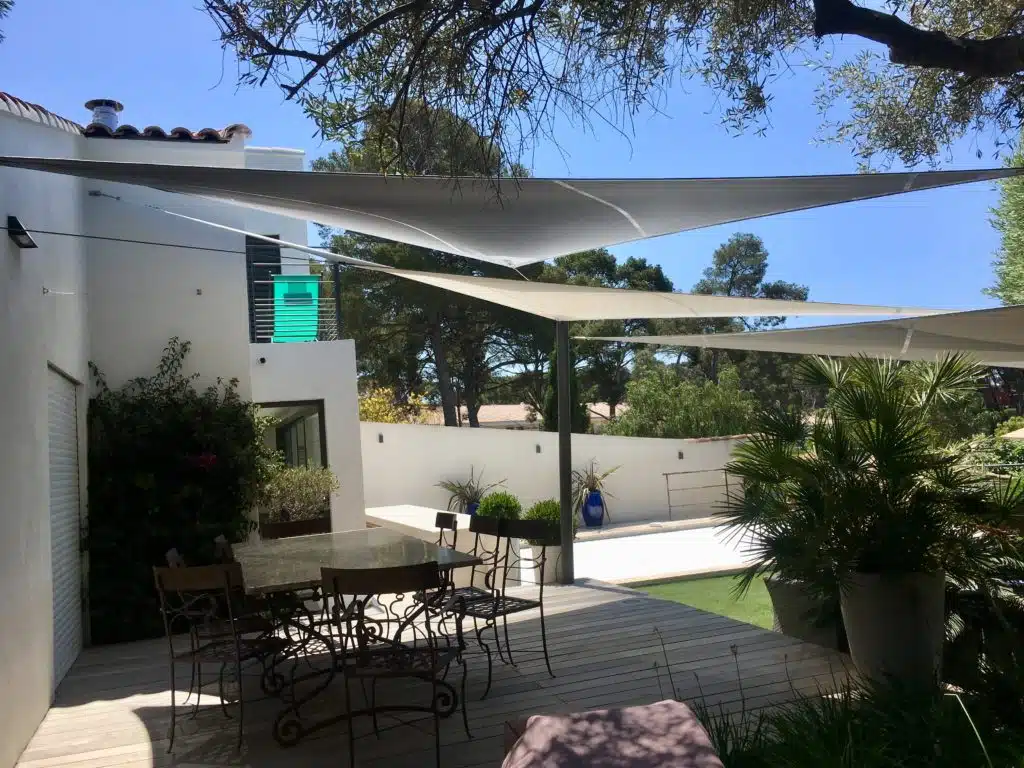 Terrasse protégée du soleil par trois voiles d'ombrage entrecroisées