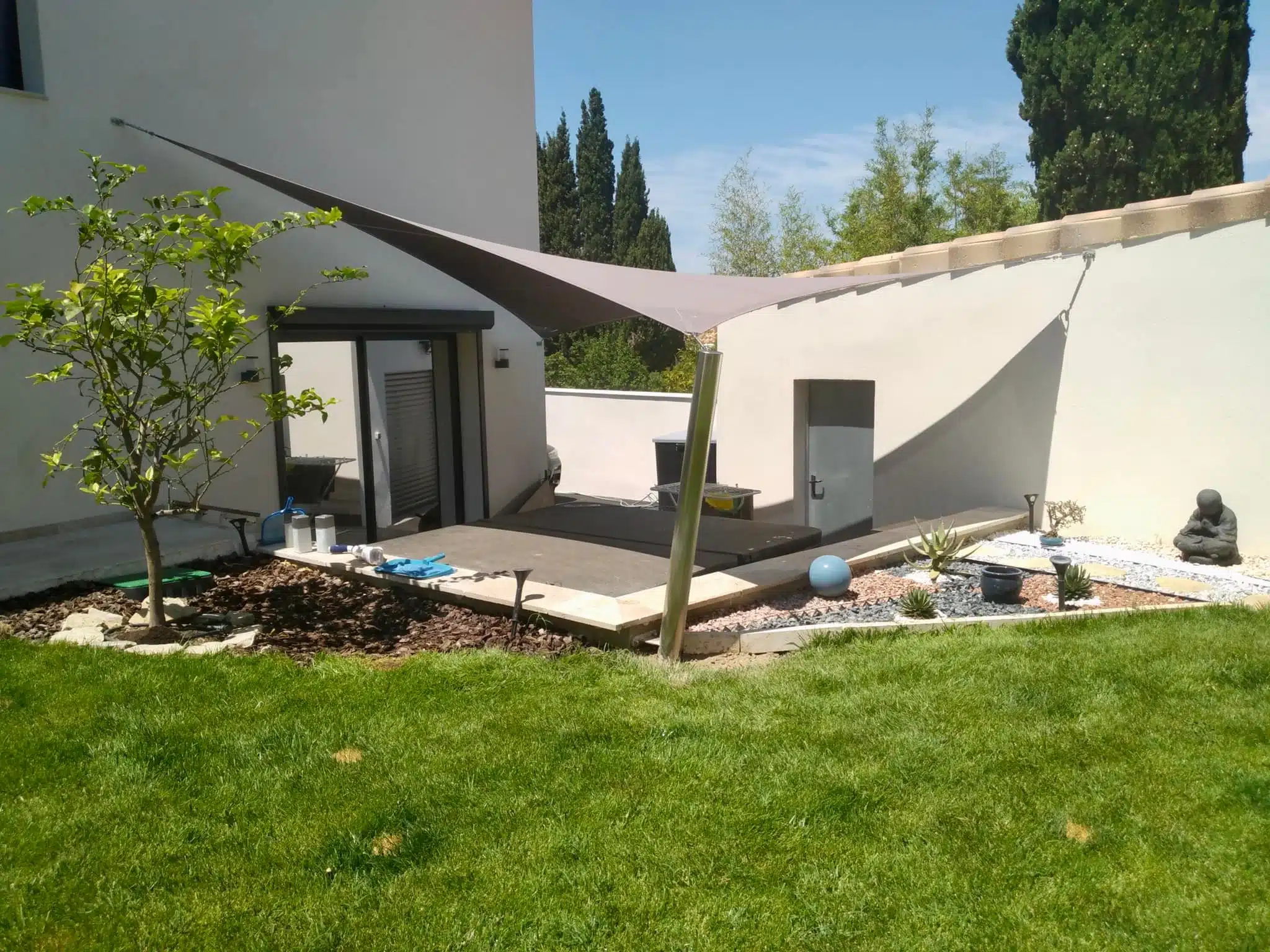 Terrasse protégée du soleil par une voile d'ombrage