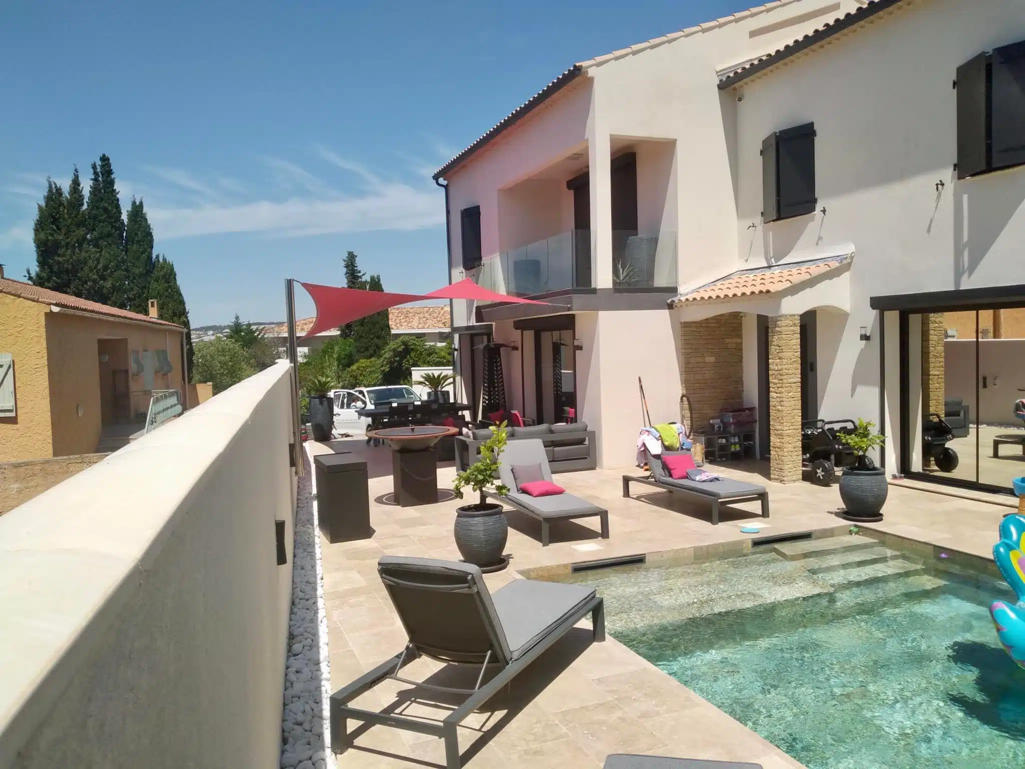 La terrasse protégée du soleil par une belle voile d'ombrage
