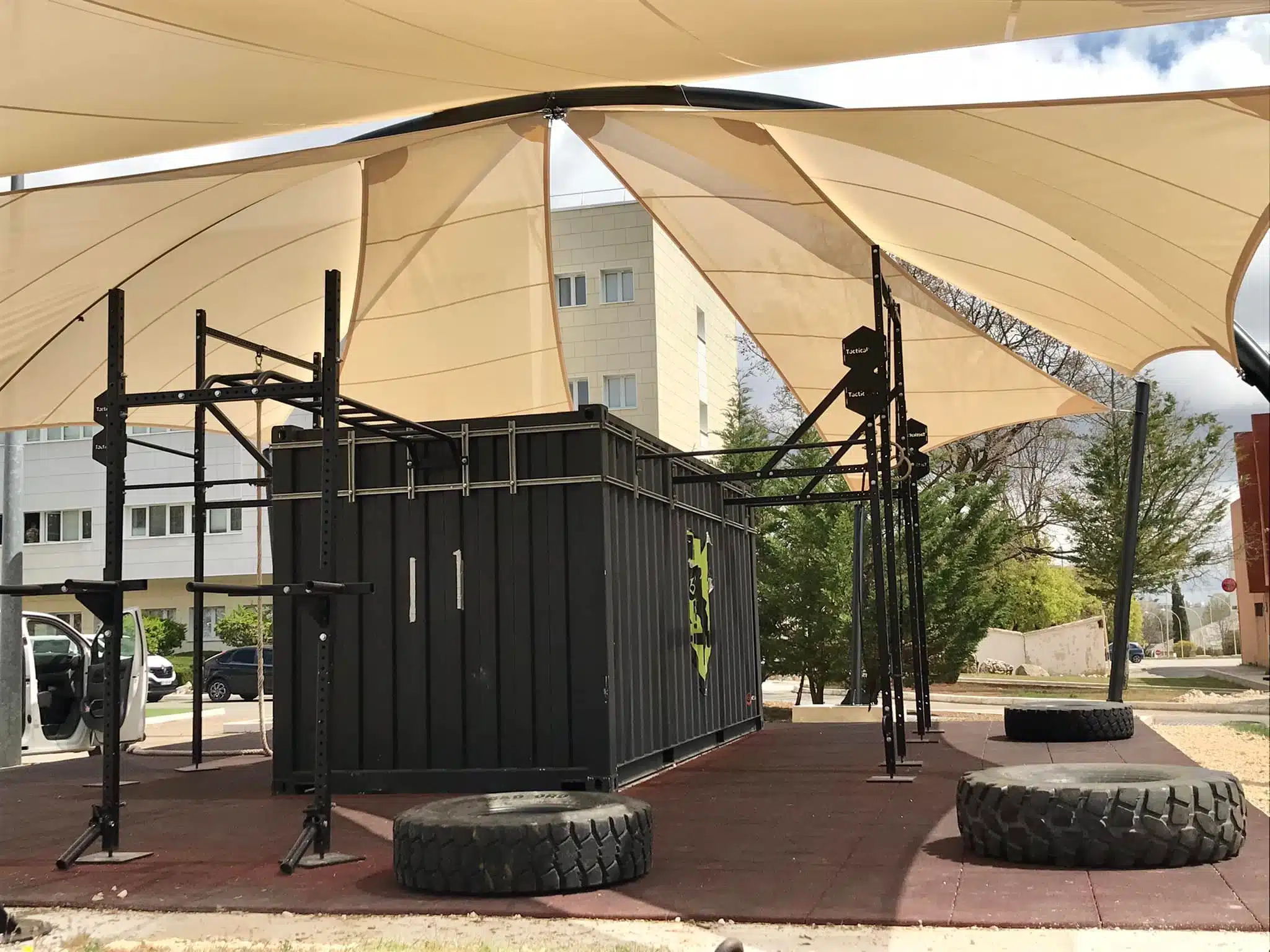 Vue d'ensemble d'une zone de crossfit en extérieur : structure métallique et voiles d'ombrage par Otaké