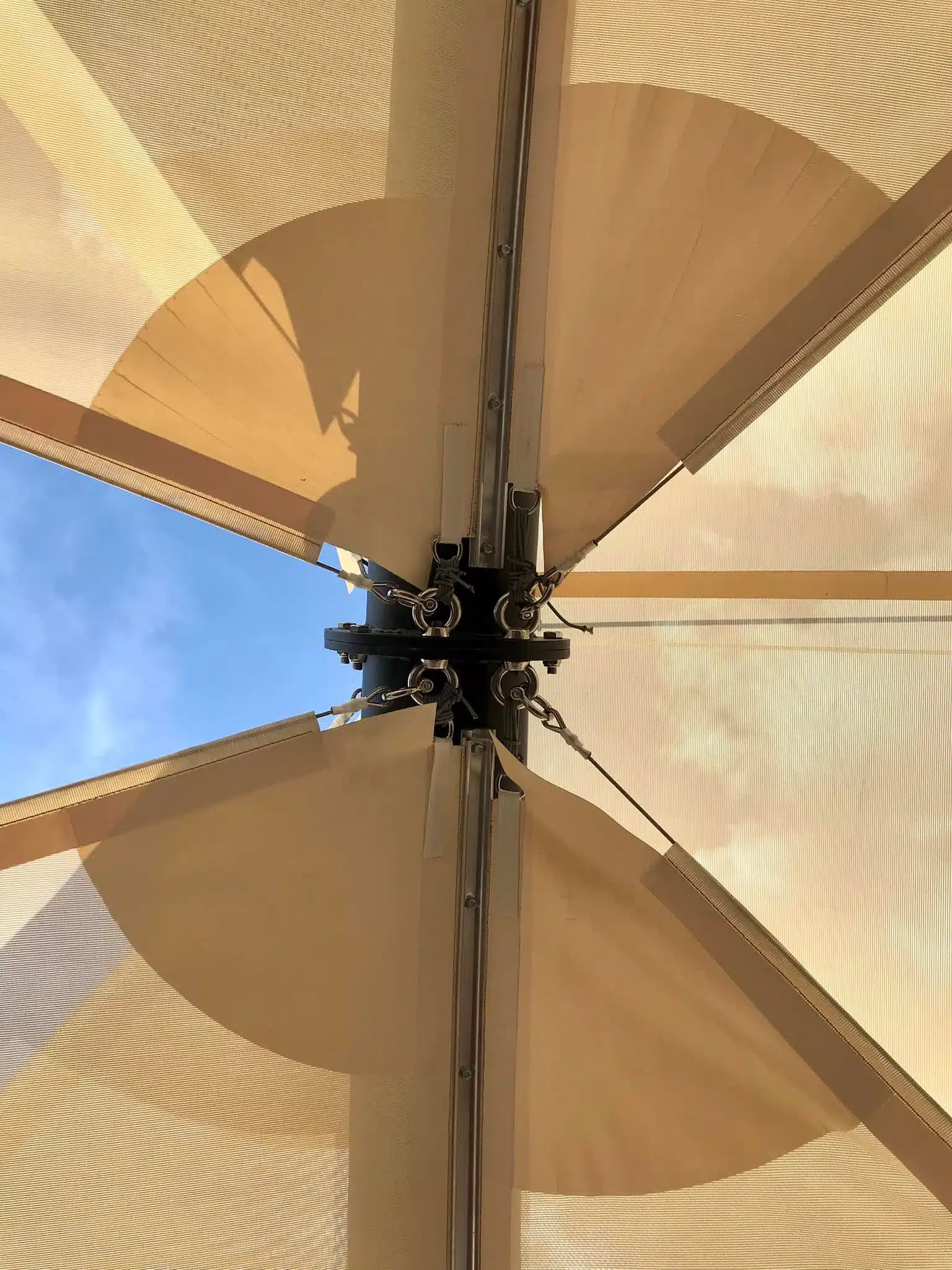 Voiles d'ombrage fixées à une solide structure, protégeant une zone de crossfit
