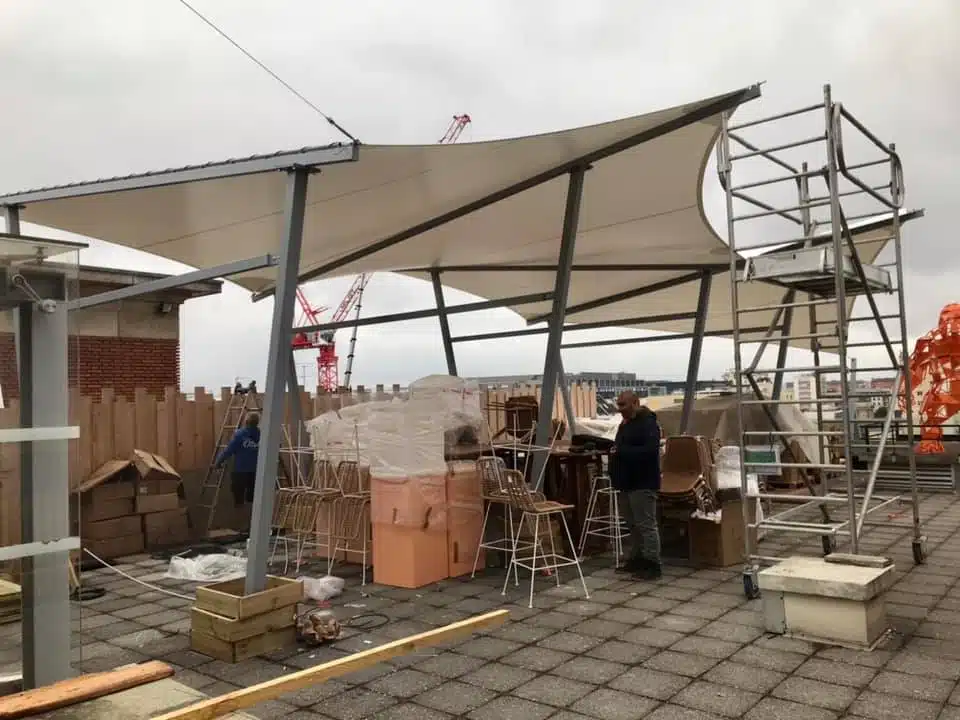 Montage de la structure pour fixer les voiles d'ombrage sur le toit-terrasse
